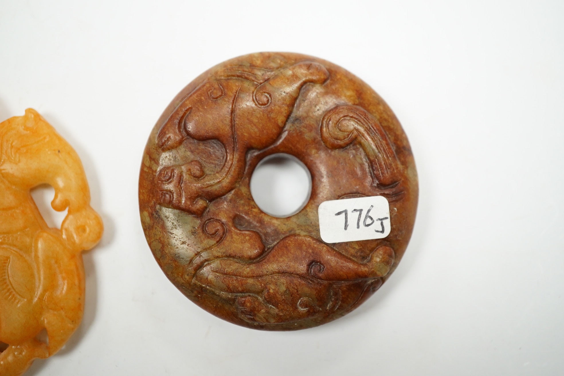 A Chinese russet and green jade bi disc and another plaque, largest 7cm diameter. Condition - good